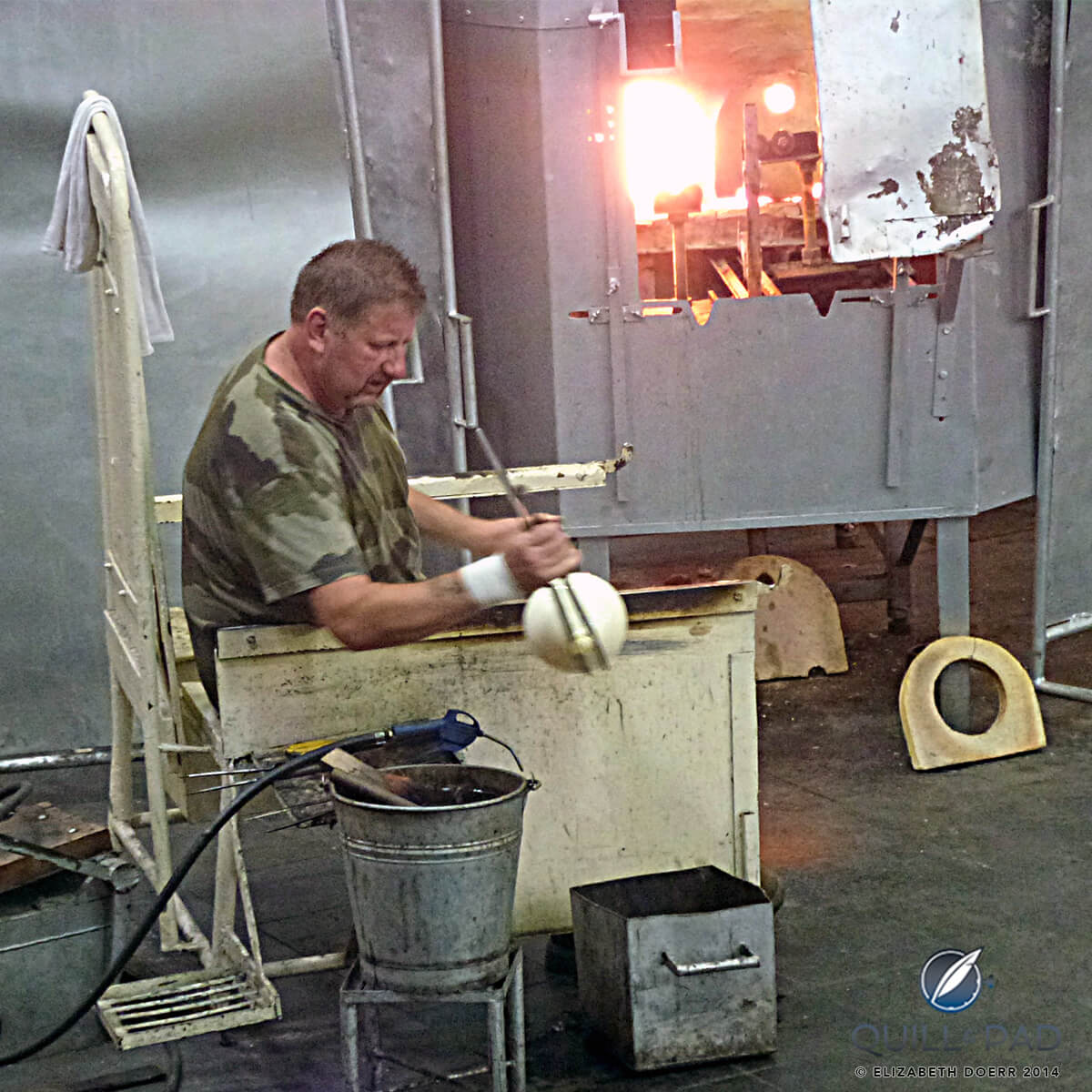 Glass blower at Les Cristalleries de Saint-Louis blowing a large glass sphere for the Jaeger-LeCoultre Hermès Edition Atmos