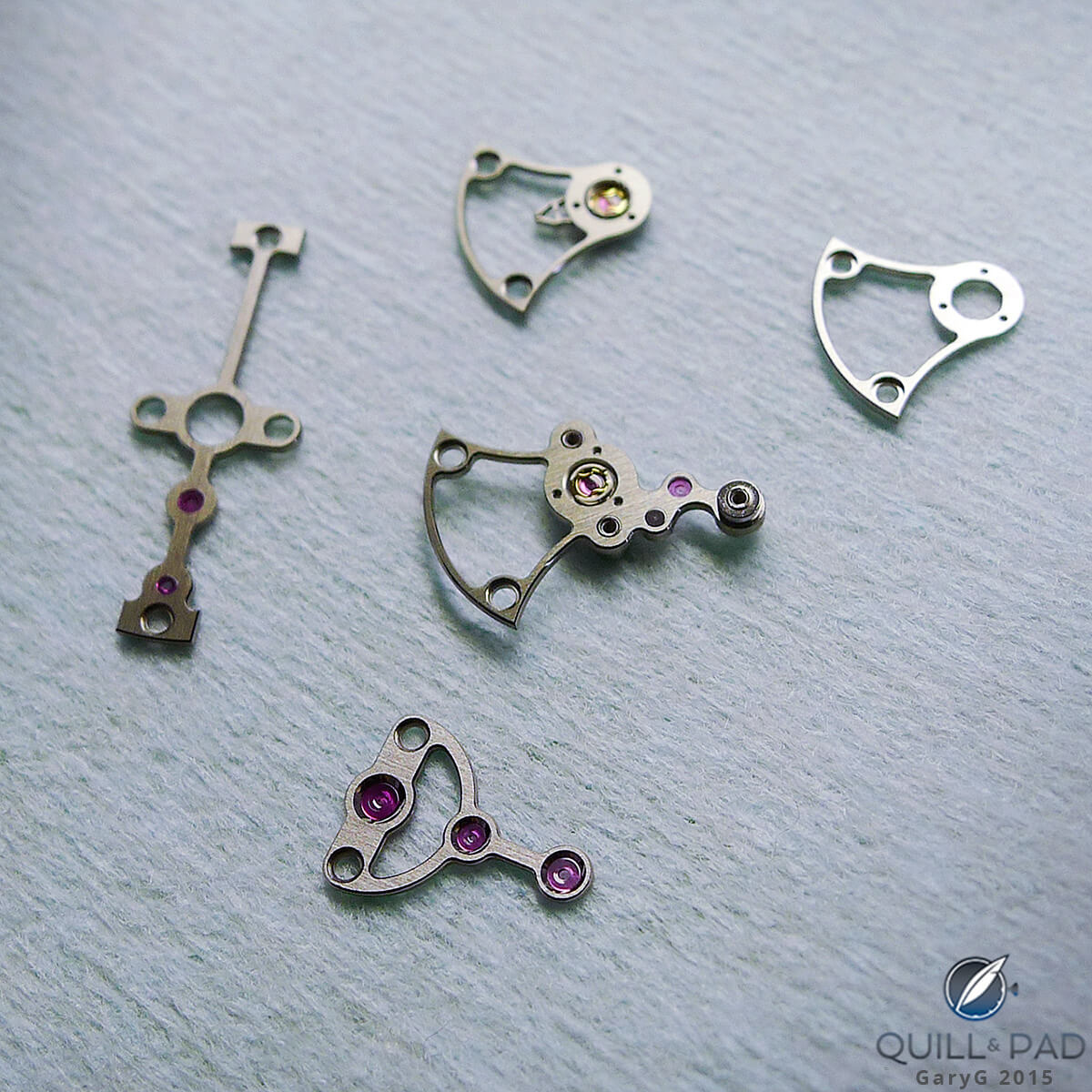 Parts for the Vianney Halter Deep Space Tourbillon in various stages of finishing