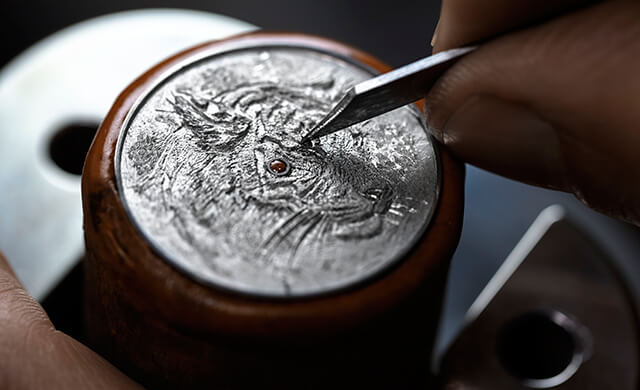 Engraver Olivier Vaucher working on what will eventually become the dial of the Hermès Arceau Tigre